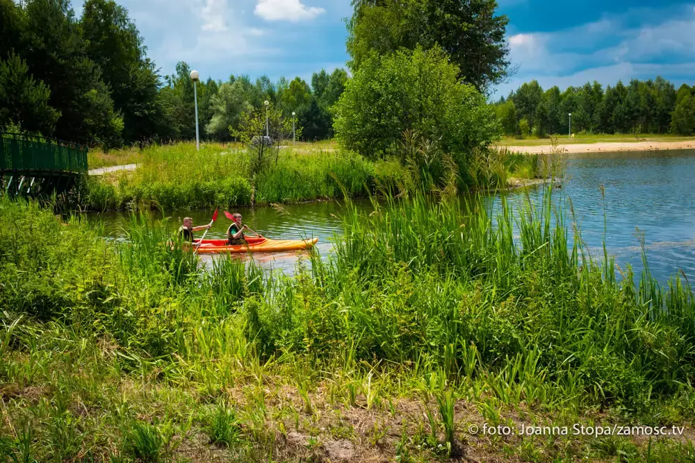 Spływ kajakowy w Zwierzyńcu na Roztoczu, malownicza rzeka i kajakarze na wodzie.